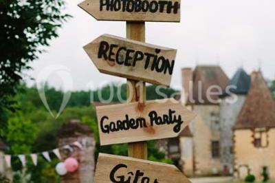 Salle de bain avec lavabo moderne, douche vitrée et miroir, dans une pièce aux poutres apparentes en bois.