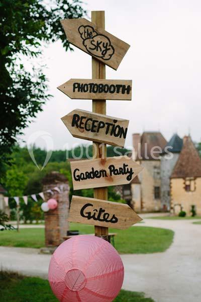 Panneau en bois avec flèches indiquant des directions pour des activités comme réception et garden party, dans un cadre…