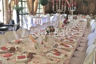 Salle de bain avec lavabo moderne, douche vitrée et miroir, dans une pièce aux poutres apparentes en bois.