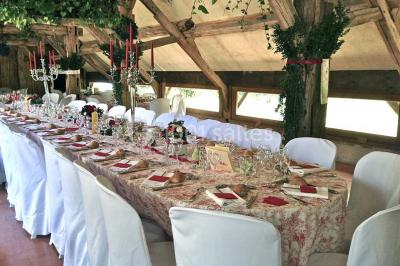 Salle de bain avec lavabo moderne, douche vitrée et miroir, dans une pièce aux poutres apparentes en bois.