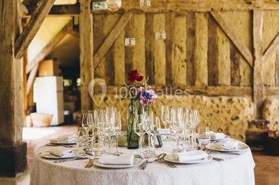Salle de bain avec lavabo moderne, douche vitrée et miroir, dans une pièce aux poutres apparentes en bois.