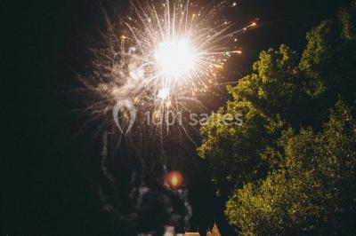Salle de bain avec lavabo moderne, douche vitrée et miroir, dans une pièce aux poutres apparentes en bois.