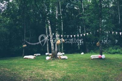 Salle de bain avec lavabo moderne, douche vitrée et miroir, dans une pièce aux poutres apparentes en bois.