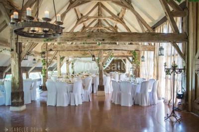 Salle de bain avec lavabo moderne, douche vitrée et miroir, dans une pièce aux poutres apparentes en bois.