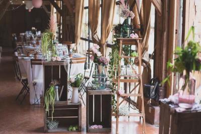 Salle de bain avec lavabo moderne, douche vitrée et miroir, dans une pièce aux poutres apparentes en bois.