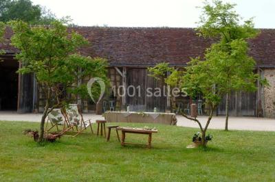 Salle de bain avec lavabo moderne, douche vitrée et miroir, dans une pièce aux poutres apparentes en bois.