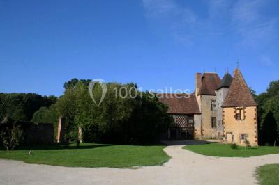 Salle de bain avec lavabo moderne, douche vitrée et miroir, dans une pièce aux poutres apparentes en bois.