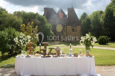 Salle de bain avec lavabo moderne, douche vitrée et miroir, dans une pièce aux poutres apparentes en bois.