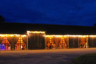 Salle de bain avec lavabo moderne, douche vitrée et miroir, dans une pièce aux poutres apparentes en bois.