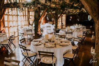 Salle de bain avec lavabo moderne, douche vitrée et miroir, dans une pièce aux poutres apparentes en bois.