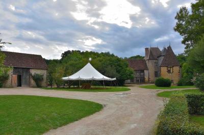 Salle de bain avec lavabo moderne, douche vitrée et miroir, dans une pièce aux poutres apparentes en bois.