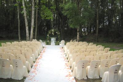 Salle de bain avec lavabo moderne, douche vitrée et miroir, dans une pièce aux poutres apparentes en bois.