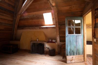 Salle de bain avec lavabo moderne, douche vitrée et miroir, dans une pièce aux poutres apparentes en bois.