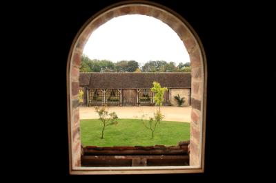Salle de bain avec lavabo moderne, douche vitrée et miroir, dans une pièce aux poutres apparentes en bois.