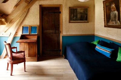 Salle de bain avec lavabo moderne, douche vitrée et miroir, dans une pièce aux poutres apparentes en bois.