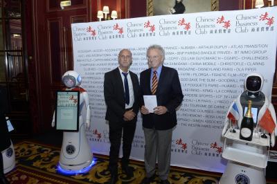 Robot humanoïde blanc équipé d'un écran et d'un plateau, présenté dans un environnement intérieur avec plantes et…