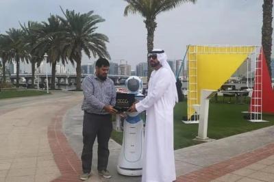 Robot humanoïde blanc équipé d'un écran et d'un plateau, présenté dans un environnement intérieur avec plantes et…