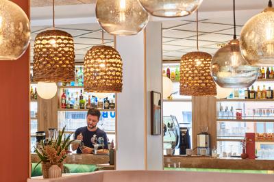 Salle de bain moderne avec douche, lavabo, miroir, toilettes et étagère murale garnie de serviettes pliées.