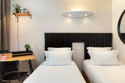 Salle de bain moderne avec douche, lavabo, miroir, toilettes et étagère murale garnie de serviettes pliées.