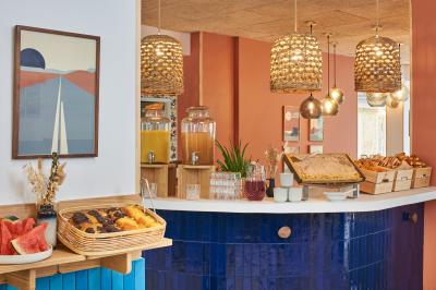 Salle de bain moderne avec douche, lavabo, miroir, toilettes et étagère murale garnie de serviettes pliées.