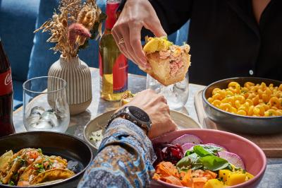 Salle de bain moderne avec douche, lavabo, miroir, toilettes et étagère murale garnie de serviettes pliées.