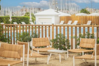 Lavabo blanc avec miroir en bois et douche à carreaux verts dans une salle de bain moderne.