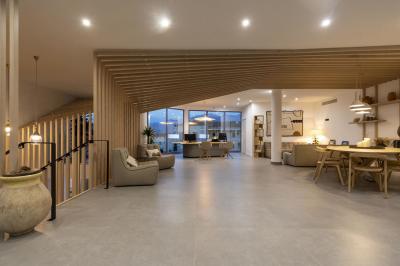 Chambre lumineuse avec lit double, décoration moderne, grande baie vitrée donnant sur une terrasse avec vue extérieure.