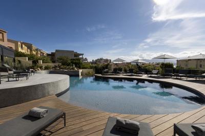 Chambre lumineuse avec lit double, décoration moderne, grande baie vitrée donnant sur une terrasse avec vue extérieure.
