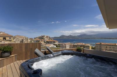 Chambre lumineuse avec lit double, décoration moderne, grande baie vitrée donnant sur une terrasse avec vue extérieure.