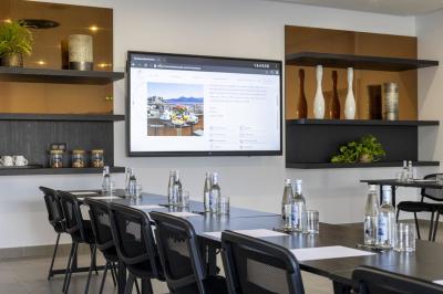 Chambre lumineuse avec lit double, décoration moderne, grande baie vitrée donnant sur une terrasse avec vue extérieure.