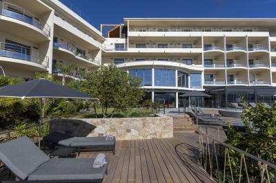 Chambre lumineuse avec lit double, décoration moderne, grande baie vitrée donnant sur une terrasse avec vue extérieure.