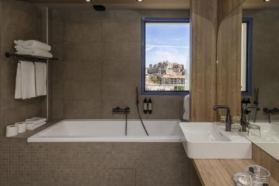 Chambre lumineuse avec lit double, décoration moderne, grande baie vitrée donnant sur une terrasse avec vue extérieure.