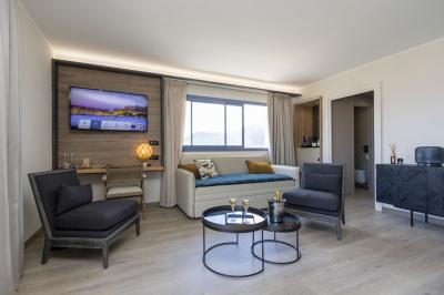 Chambre lumineuse avec lit double, décoration moderne, grande baie vitrée donnant sur une terrasse avec vue extérieure.