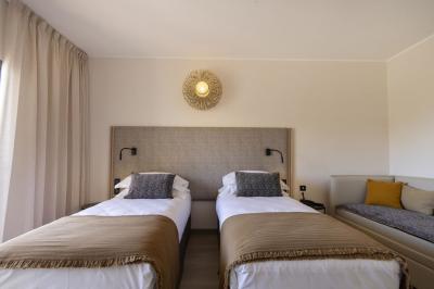 Chambre lumineuse avec lit double, décoration moderne, grande baie vitrée donnant sur une terrasse avec vue extérieure.