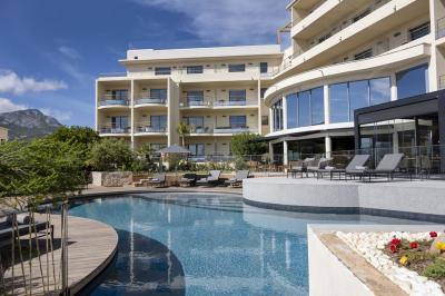 Chambre lumineuse avec lit double, décoration moderne, grande baie vitrée donnant sur une terrasse avec vue extérieure.
