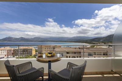 Chambre lumineuse avec lit double, décoration moderne, grande baie vitrée donnant sur une terrasse avec vue extérieure.