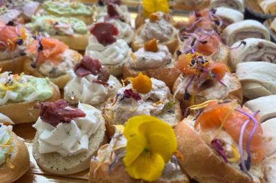 Assiette de légumes rôtis avec pommes de terre violettes, garnie de pousses fraîches et de fleurs comestibles.