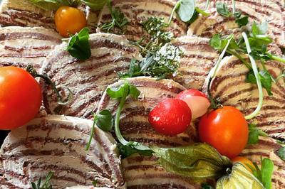 Assiette de légumes rôtis avec pommes de terre violettes, garnie de pousses fraîches et de fleurs comestibles.