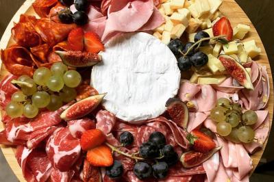 Assiette de légumes rôtis avec pommes de terre violettes, garnie de pousses fraîches et de fleurs comestibles.