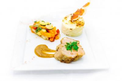 Assiette de légumes rôtis avec pommes de terre violettes, garnie de pousses fraîches et de fleurs comestibles.