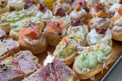 Assiette de légumes rôtis avec pommes de terre violettes, garnie de pousses fraîches et de fleurs comestibles.