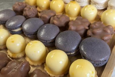 Assiette de légumes rôtis avec pommes de terre violettes, garnie de pousses fraîches et de fleurs comestibles.