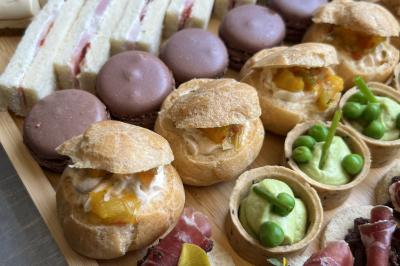 Assiette de légumes rôtis avec pommes de terre violettes, garnie de pousses fraîches et de fleurs comestibles.