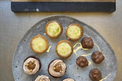 Assiette de légumes rôtis avec pommes de terre violettes, garnie de pousses fraîches et de fleurs comestibles.
