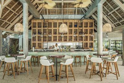 Miniature Location salle Flic-en-Flacq (District de Rivière Noire) - Hôtel Sugar Beach #10 Chambre lumineuse avec lit double, bureau, fauteuil, étagères en bois et vue sur une salle de bain ouverte.