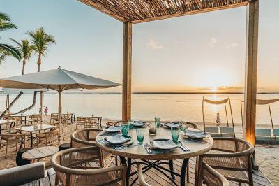 Miniature Location salle Flic-en-Flacq (District de Rivière Noire) - Hôtel Sugar Beach #5 Chambre lumineuse avec lit double, bureau, fauteuil, étagères en bois et vue sur une salle de bain ouverte.