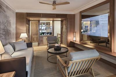 Miniature Location salle Flic-en-Flacq (District de Rivière Noire) - Hôtel Sugar Beach #15 Chambre lumineuse avec lit double, bureau, fauteuil, étagères en bois et vue sur une salle de bain ouverte.