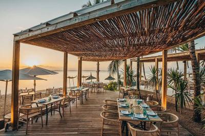 Miniature Location salle Flic-en-Flacq (District de Rivière Noire) - Hôtel Sugar Beach #7 Chambre lumineuse avec lit double, bureau, fauteuil, étagères en bois et vue sur une salle de bain ouverte.