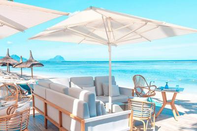 Miniature Location salle Flic-en-Flacq (District de Rivière Noire) - Hôtel Sugar Beach #8 Chambre lumineuse avec lit double, bureau, fauteuil, étagères en bois et vue sur une salle de bain ouverte.