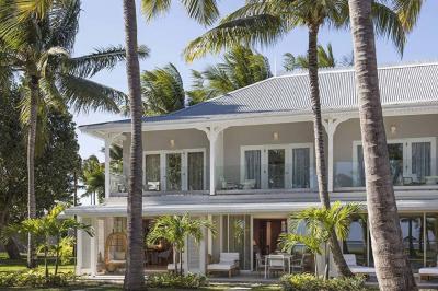 Miniature Location salle Flic-en-Flacq (District de Rivière Noire) - Hôtel Sugar Beach #3 Chambre lumineuse avec lit double, bureau, fauteuil, étagères en bois et vue sur une salle de bain ouverte.